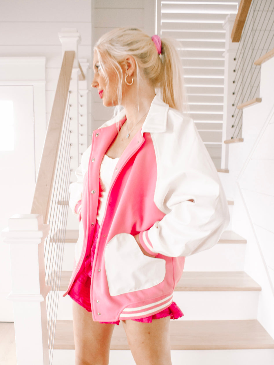 Pink and white Letterman ladies jacket with contrasting sleeves and striped cuffs.
