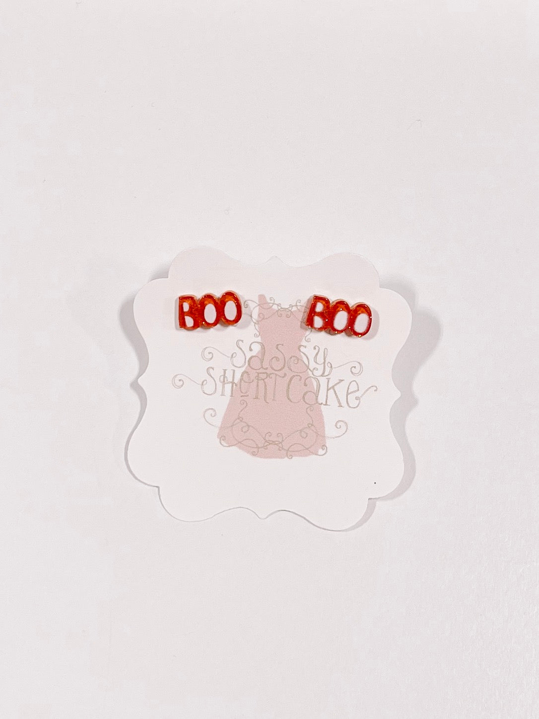Red "Boo" Halloween mini stud earrings displayed on a card.
