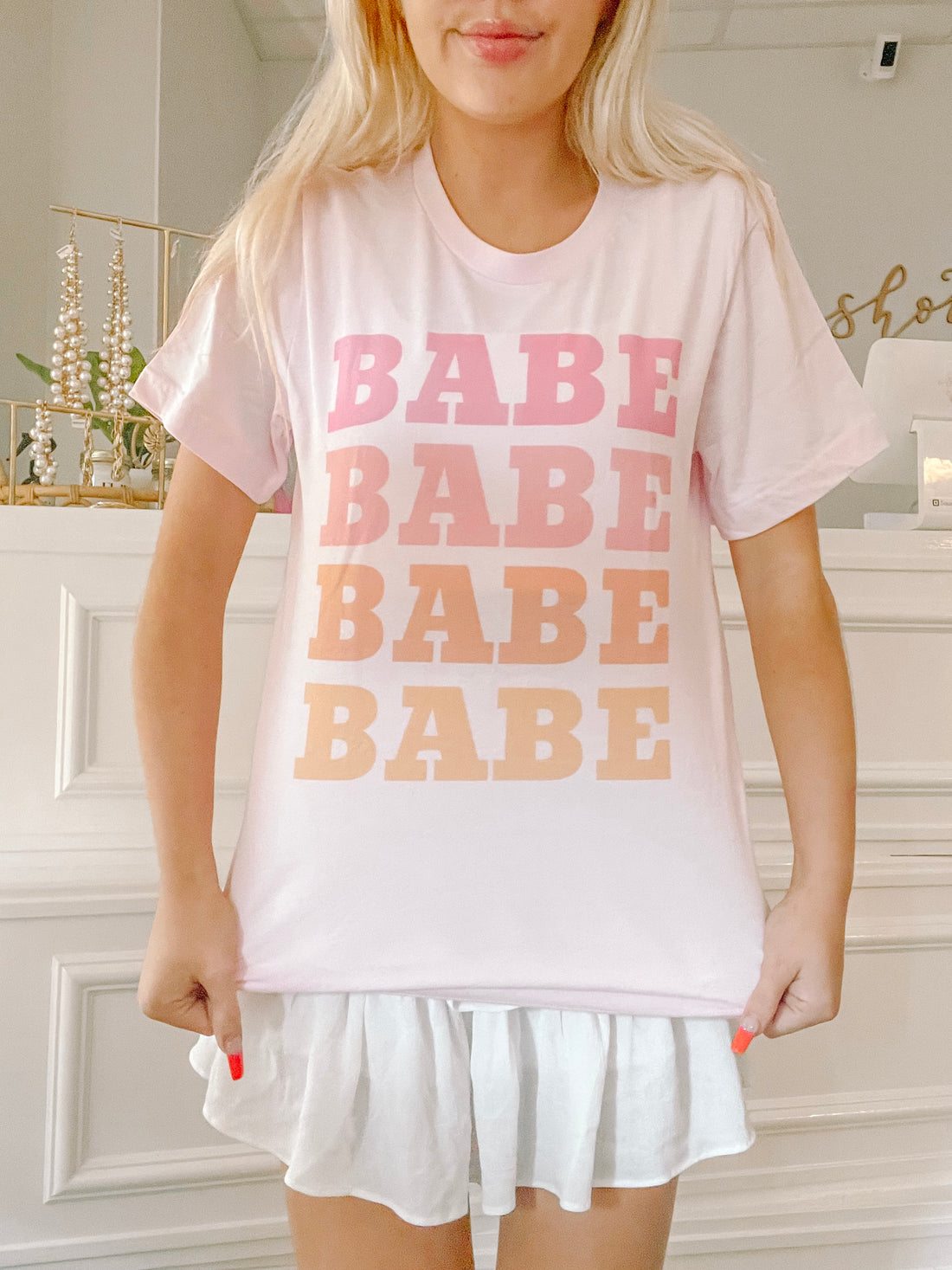 Pink Babe Tee:  Soft pink tee featuring a repeated "Babe" graphic in ombre shades of pink and orange.
