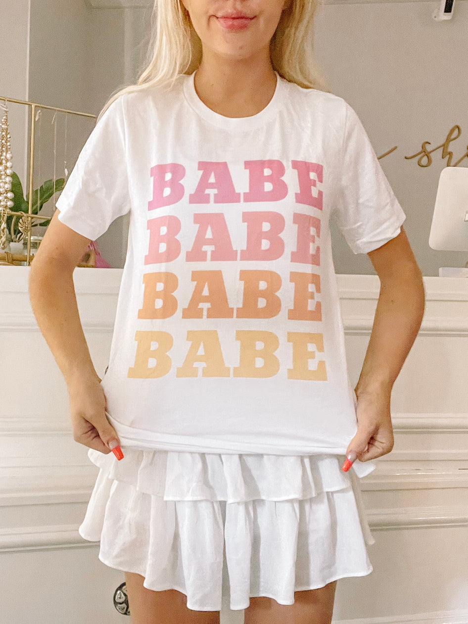 White Babe Tee with ombre pink and orange "Babe" graphic.
