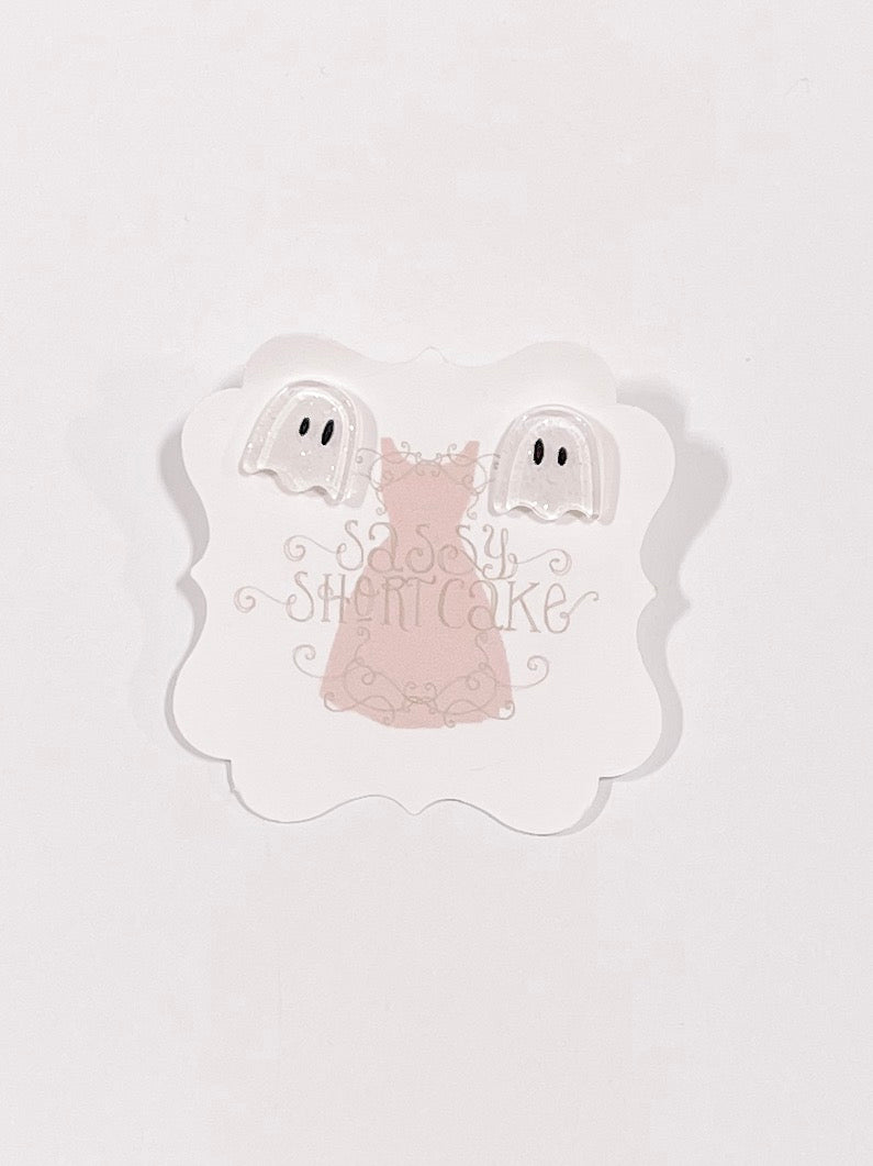 Adorable ghost-shaped Halloween earrings displayed on a pink card.
