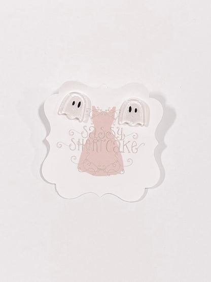 Adorable ghost-shaped Halloween earrings displayed on a pink card.
