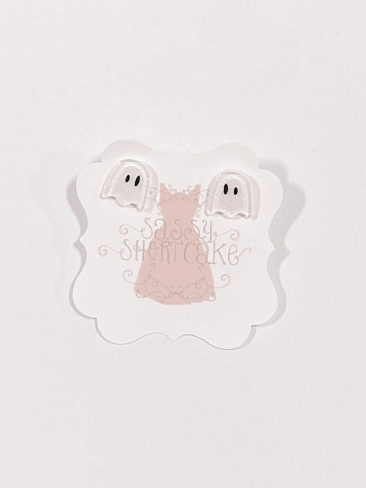 Adorable ghost-shaped Halloween earrings displayed on a pink card.

