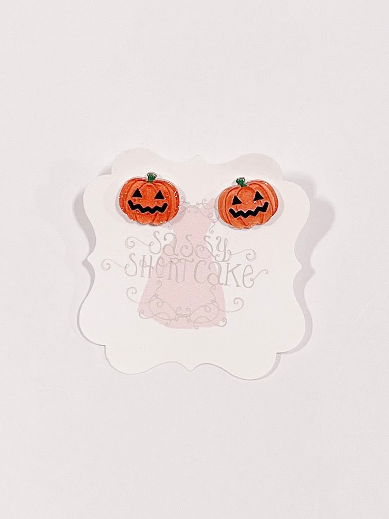 Mini jack-o'-lantern Halloween earrings displayed on a card.
