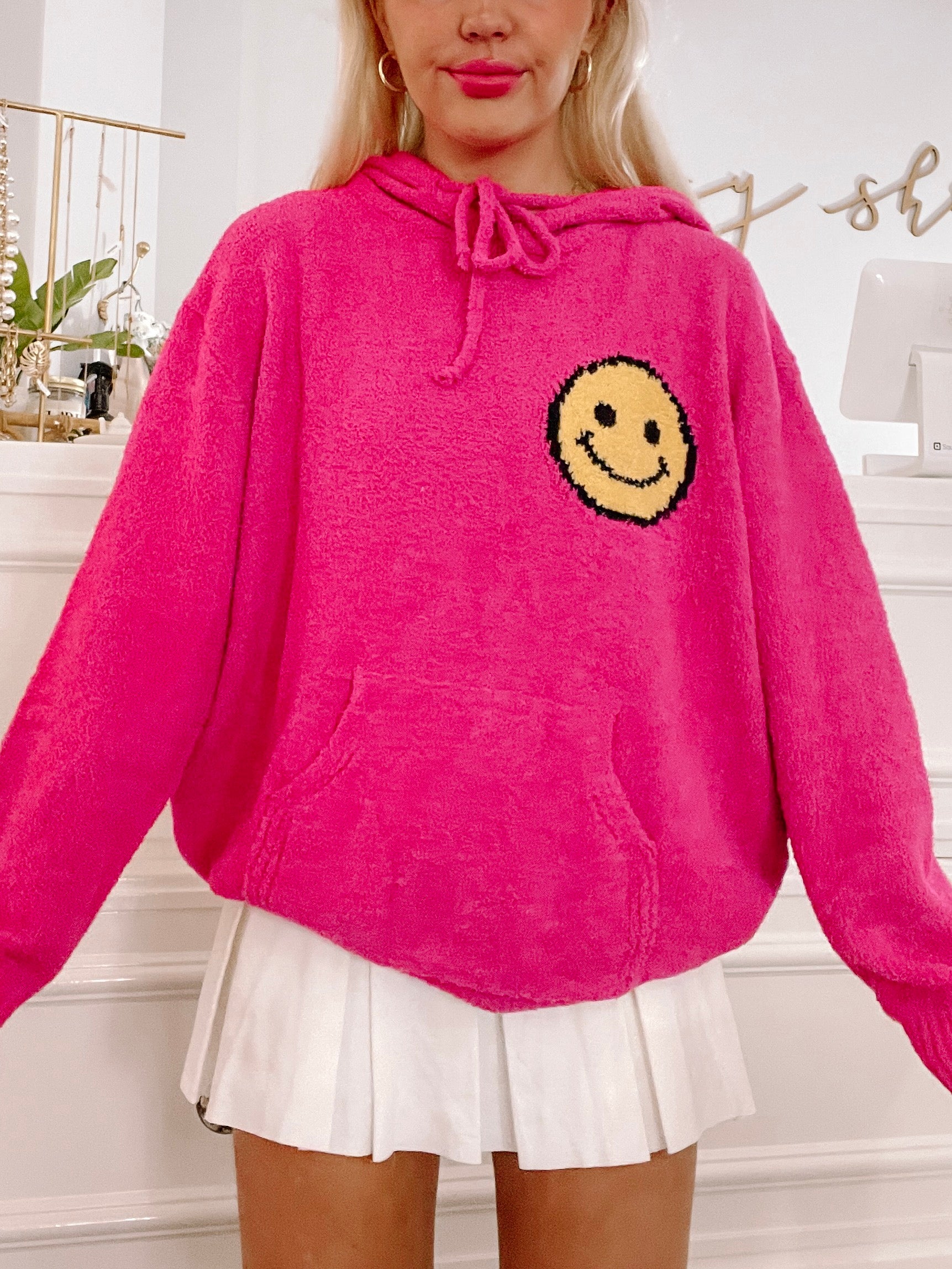 Pink fuzzy Be Happy hoodie with smiley face detail
