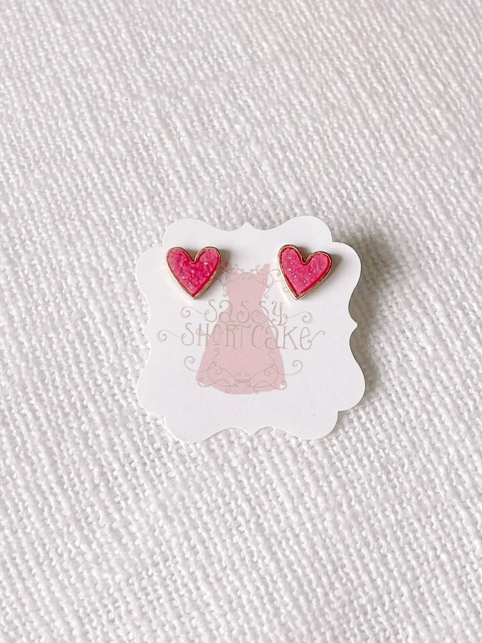 Pink glitter heart stud earrings with gold accents
