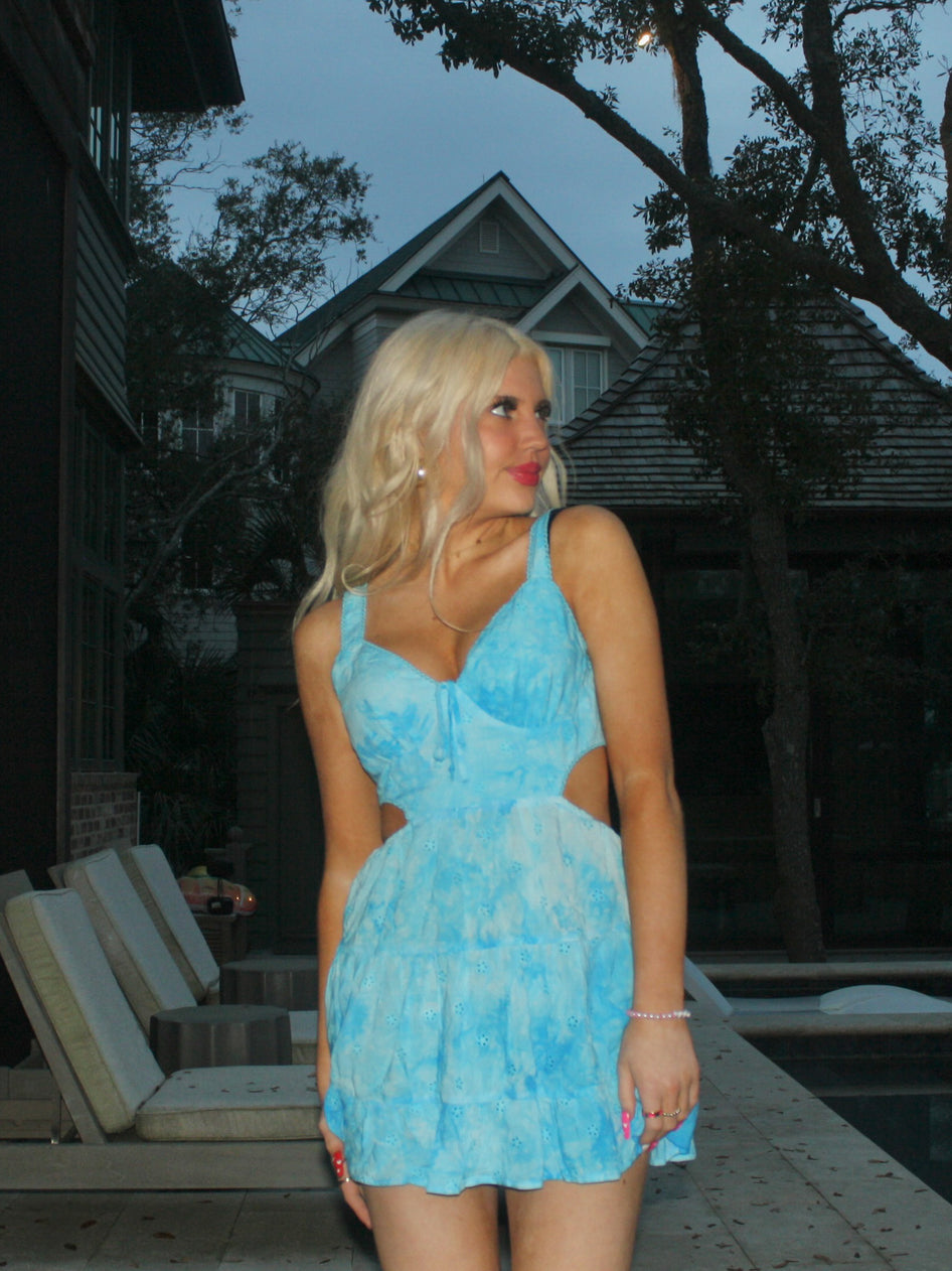 Light blue eyelet mini dress with cutouts, worn outdoors near a pool.
