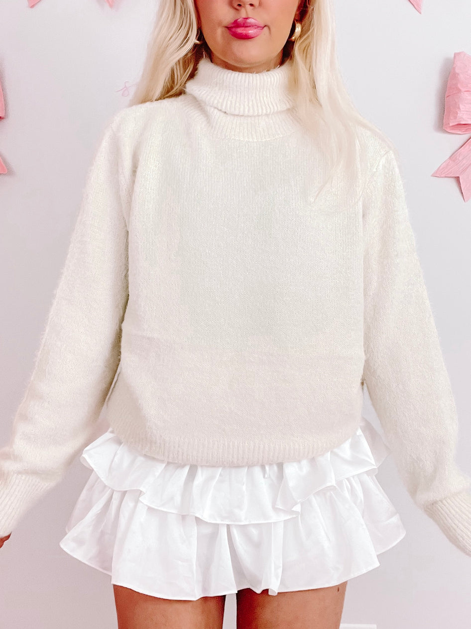 Cream Perla turtleneck sweater, soft knit fabric.
