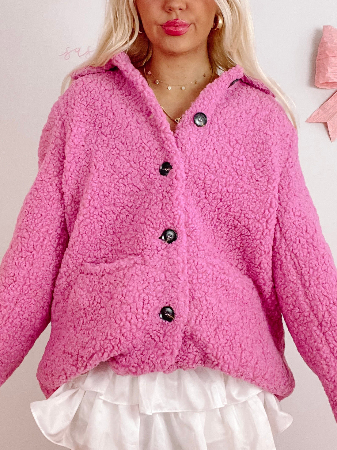 Pink teddy-style shacket with button closures, shown on a model.
