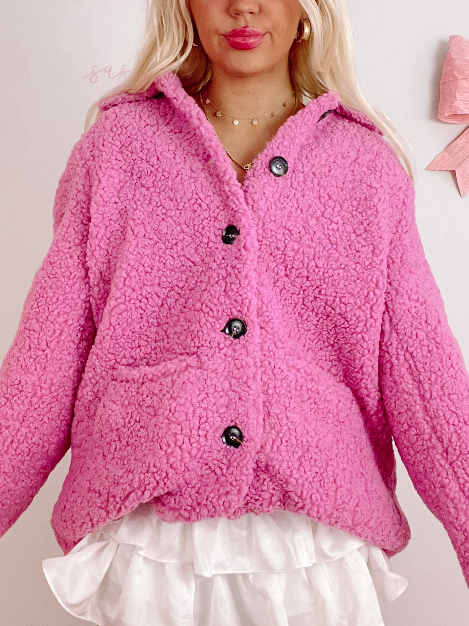 Pink teddy-style shacket with button closures, shown on a model.
