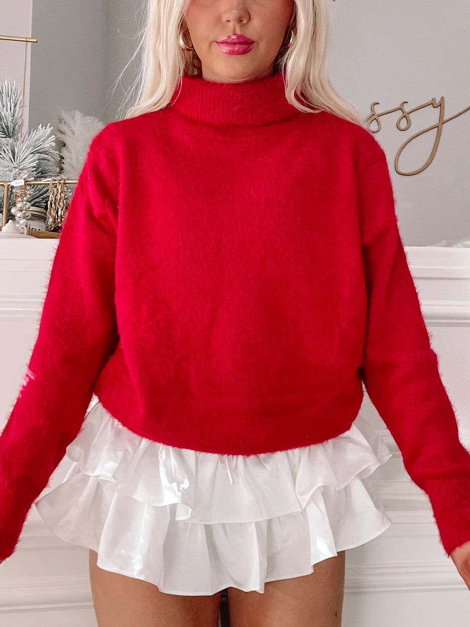 Perla Sweater in red: fuzzy, cozy turtleneck for a festive look.
