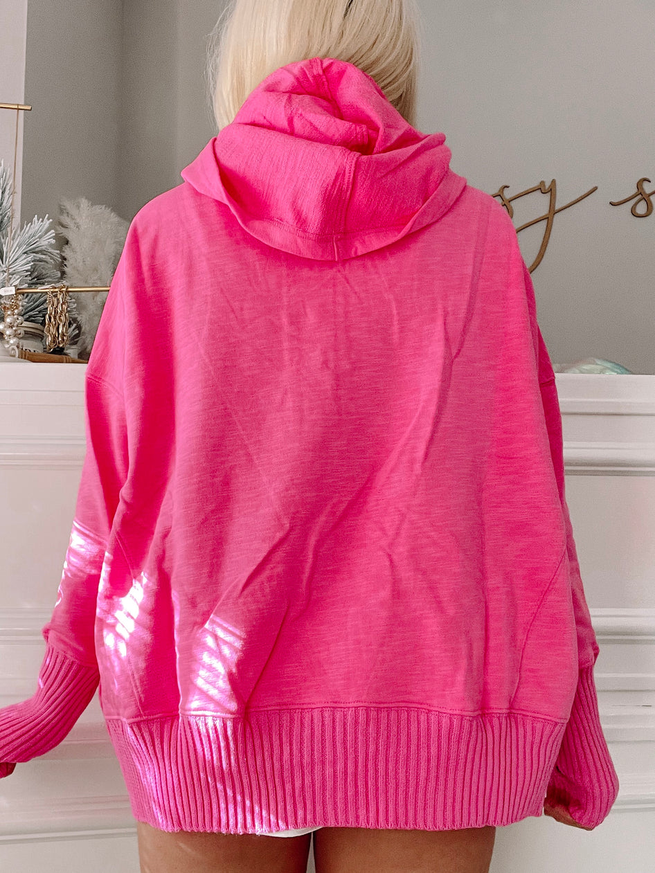 Hot pink pullover sweater with ribbed cuffs and hem, shown from the back.
