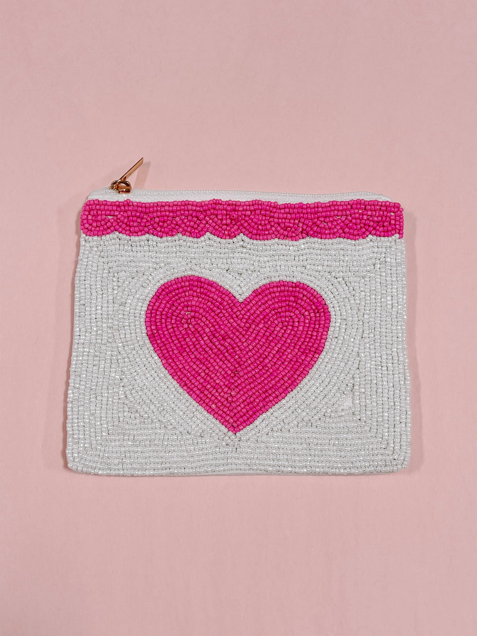Beaded pouch with pink heart design, white background, and gold zipper.
