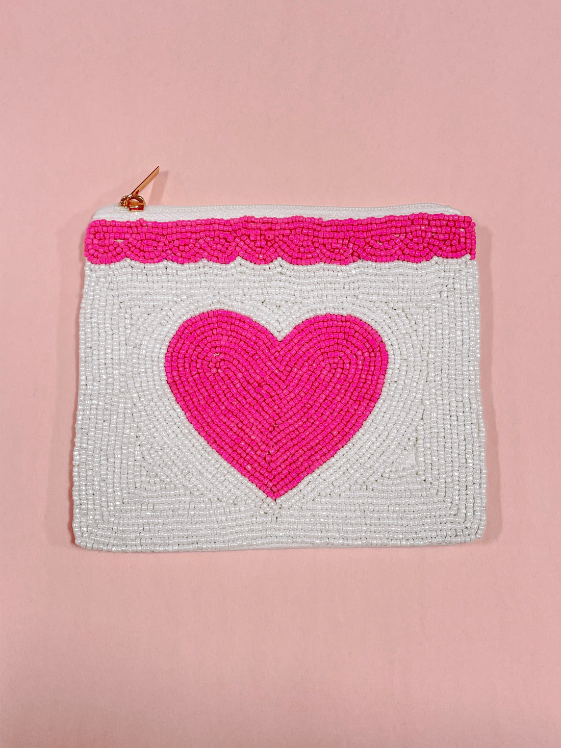 White beaded pouch with pink heart design, gold zipper.

