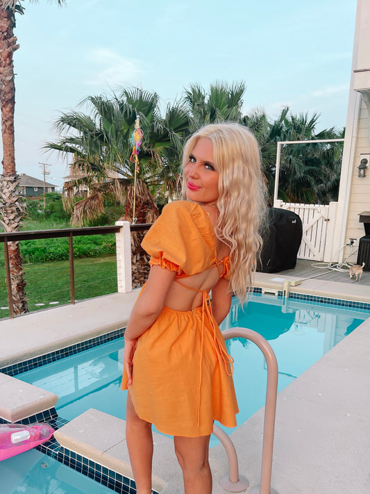 Orange Golden Hour Glam dress with puff sleeves and open back, perfect for summer.
