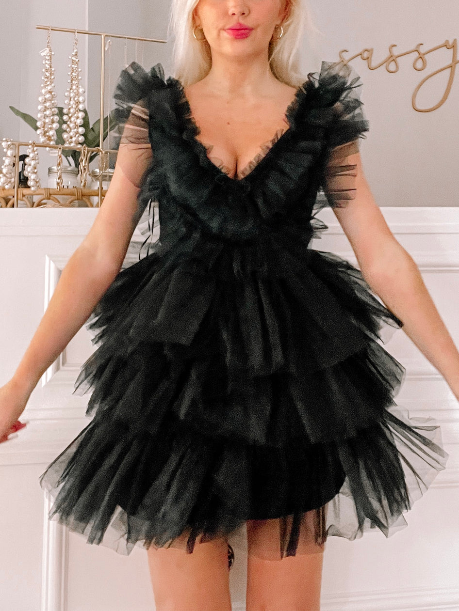 Black tulle mini dress with tiered ruffles and V-neckline.
