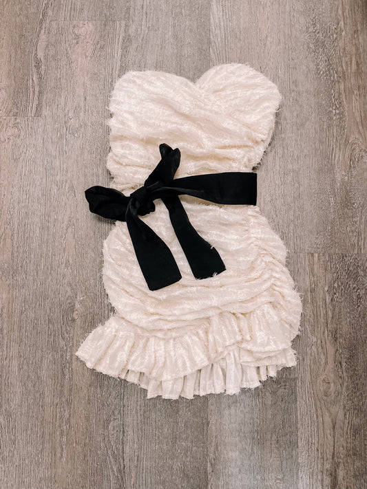 Cream ruffled Vanilla Bean dress with black ribbon belt.

