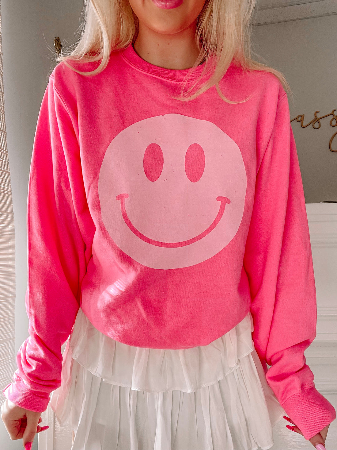 Hot pink crewneck sweatshirt with a large, light pink smiley face graphic.
