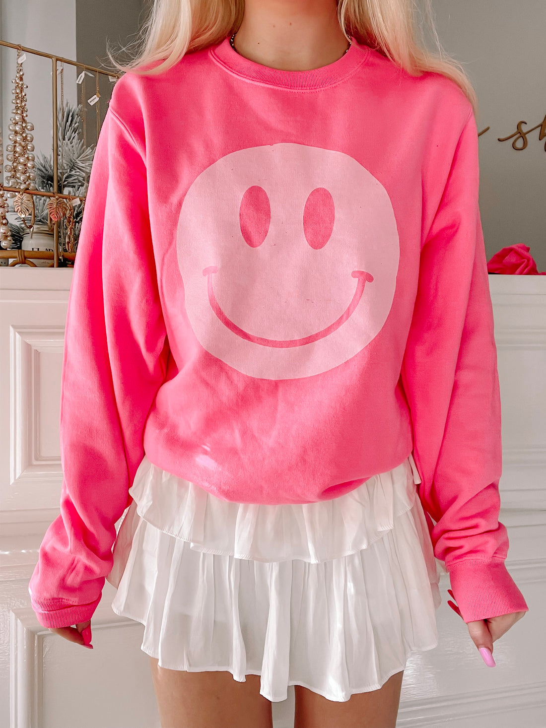 Hot pink crewneck sweatshirt featuring a large, light pink smiley face graphic.

