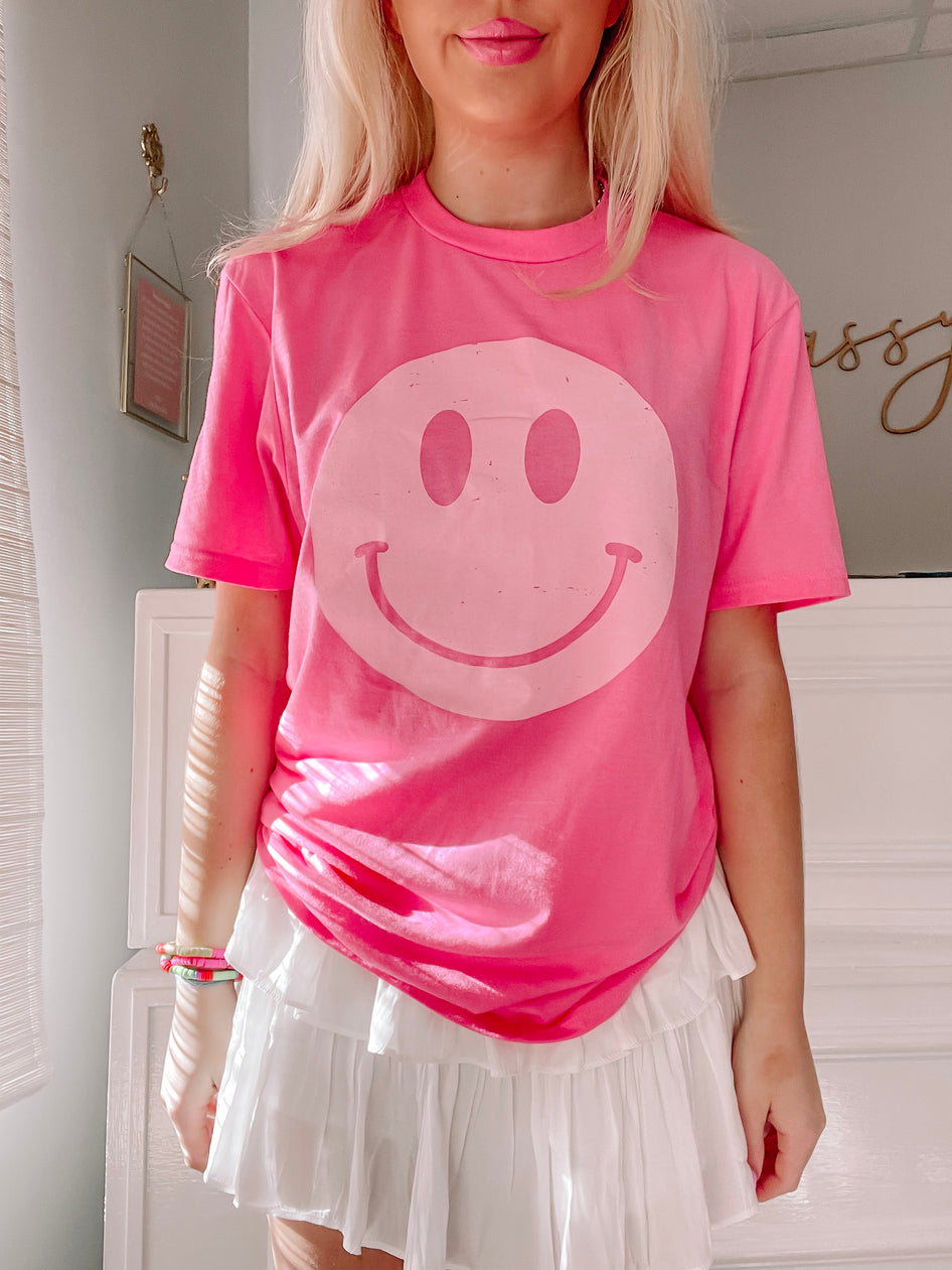 Hot Pink Happy Tee:  A cheerful hot pink tee featuring a large, off-white smiley face graphic.
