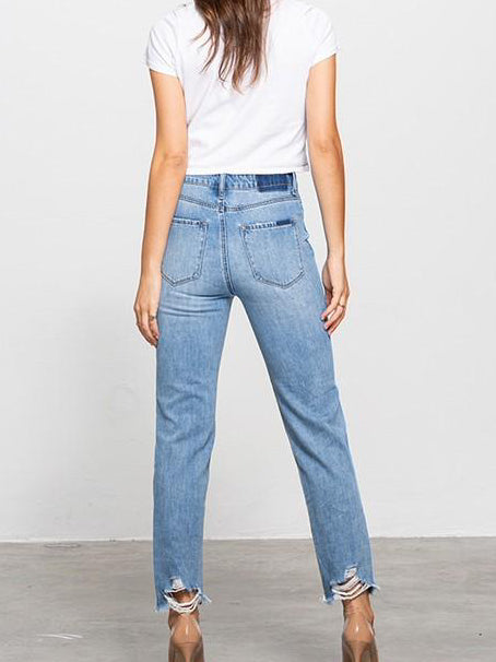 Light wash, distressed jeans with frayed hems;  model view from behind.
