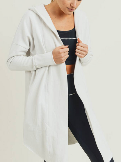Off-white hooded cardigan, long and open-front, worn over black leggings.
