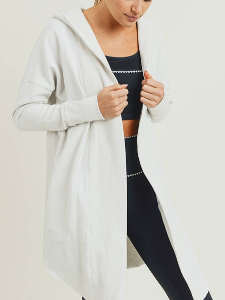 Off-white hooded cardigan, long and open-front, worn over black leggings.

