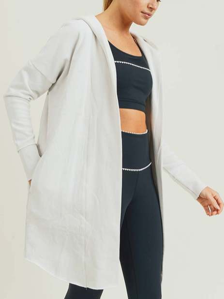 Off-white hooded longline cardigan, perfect for layering over workout clothes.
