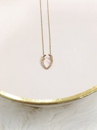 Gold antler charm necklace on delicate chain.
