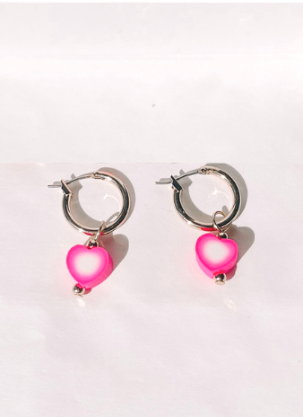 Gold hoop earrings with pink heart charms.
