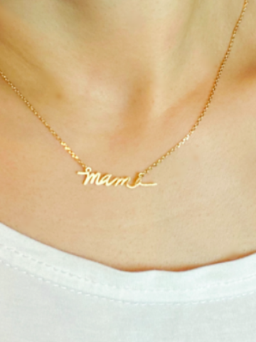 Gold "mamie" script necklace on a model.
