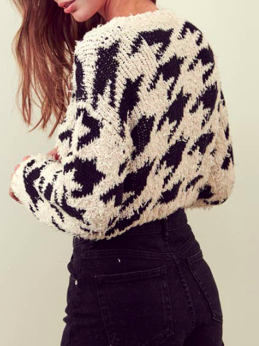 Cream and black patterned knit sweater, shown on model.
