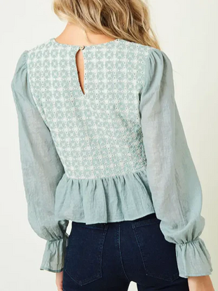 Mint green embroidered peasant top with long sleeves and a ruffled hem.
