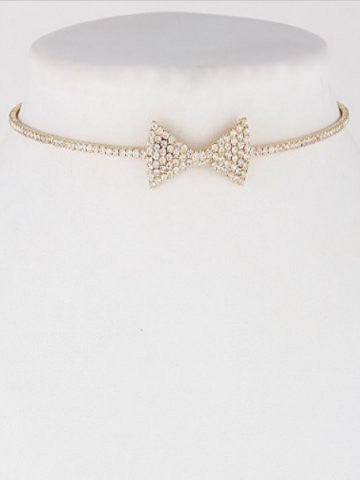 Gold choker necklace featuring a sparkling rhinestone bow.
