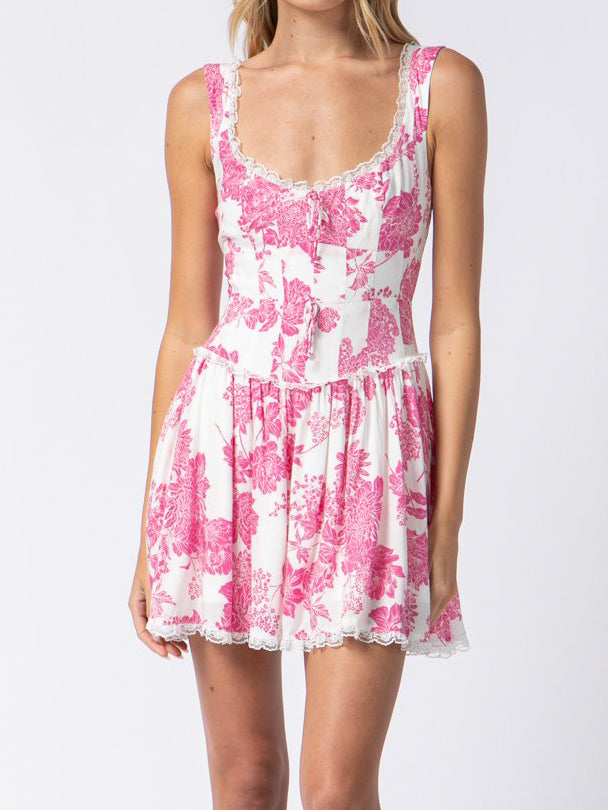 White eyelet-trimmed mini dress with a pink floral print.
