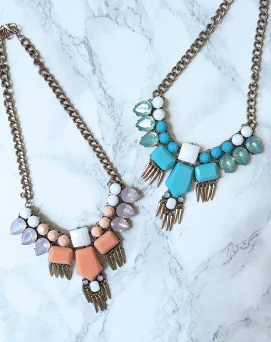 Empire Necklace | Mint: Two statement necklaces, one teal & white, one peach & lavender, featuring gold chain & ornate gemstone accents.
