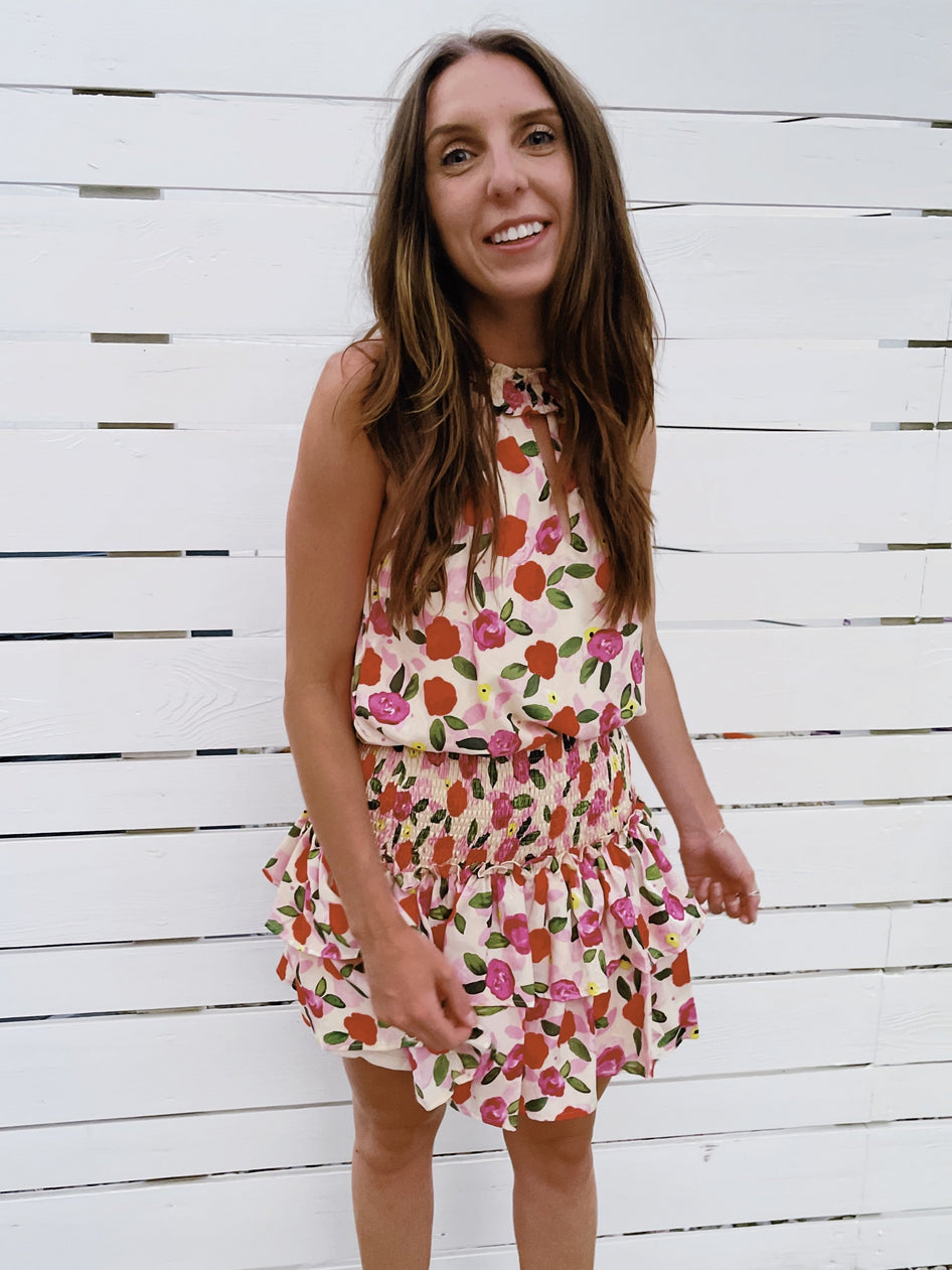 Floral Sachet Dress:  Cream ruffled mini dress with pink and red roses, perfect for summer.
