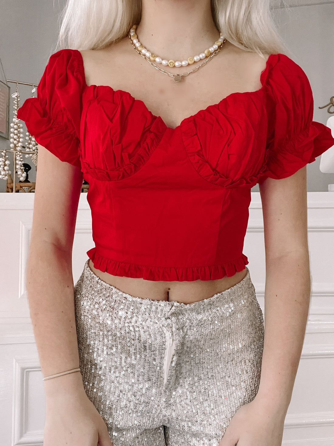 Red Happy Holly puff-sleeve crop top with ruffle trim.
