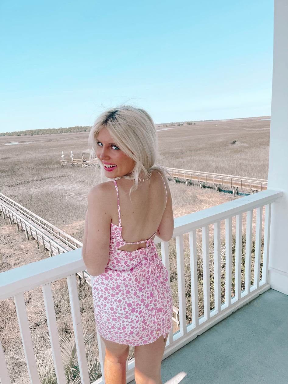 Pink floral mini dress on a porch overlooking a marsh.
