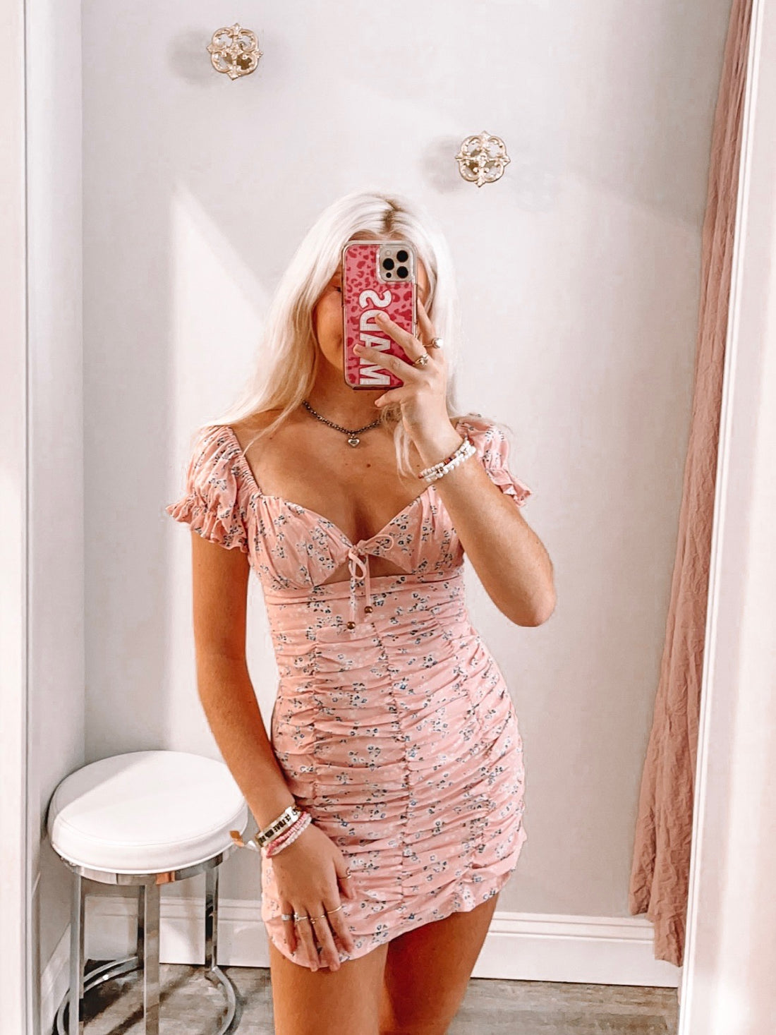 Pink floral mini dress with puff sleeves and a ruched bodice.
