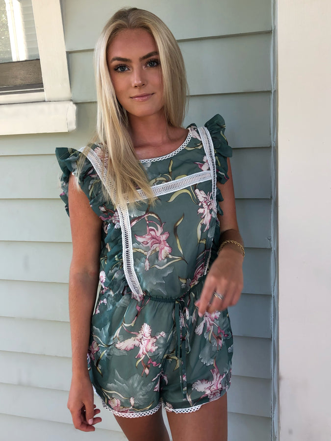 Paradise Romper: Green floral print romper with white lace trim and ruffle sleeves.

