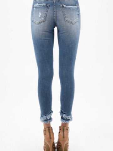 Light wash distressed skinny jeans with frayed hems, shown from the back.
