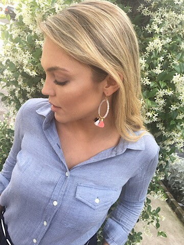 First Class Tassel Earrings: Beaded hoop earrings with coral and white tassels.
