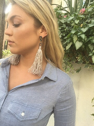 Beige tassel earrings with dark gray chain detail; stylish statement piece.
