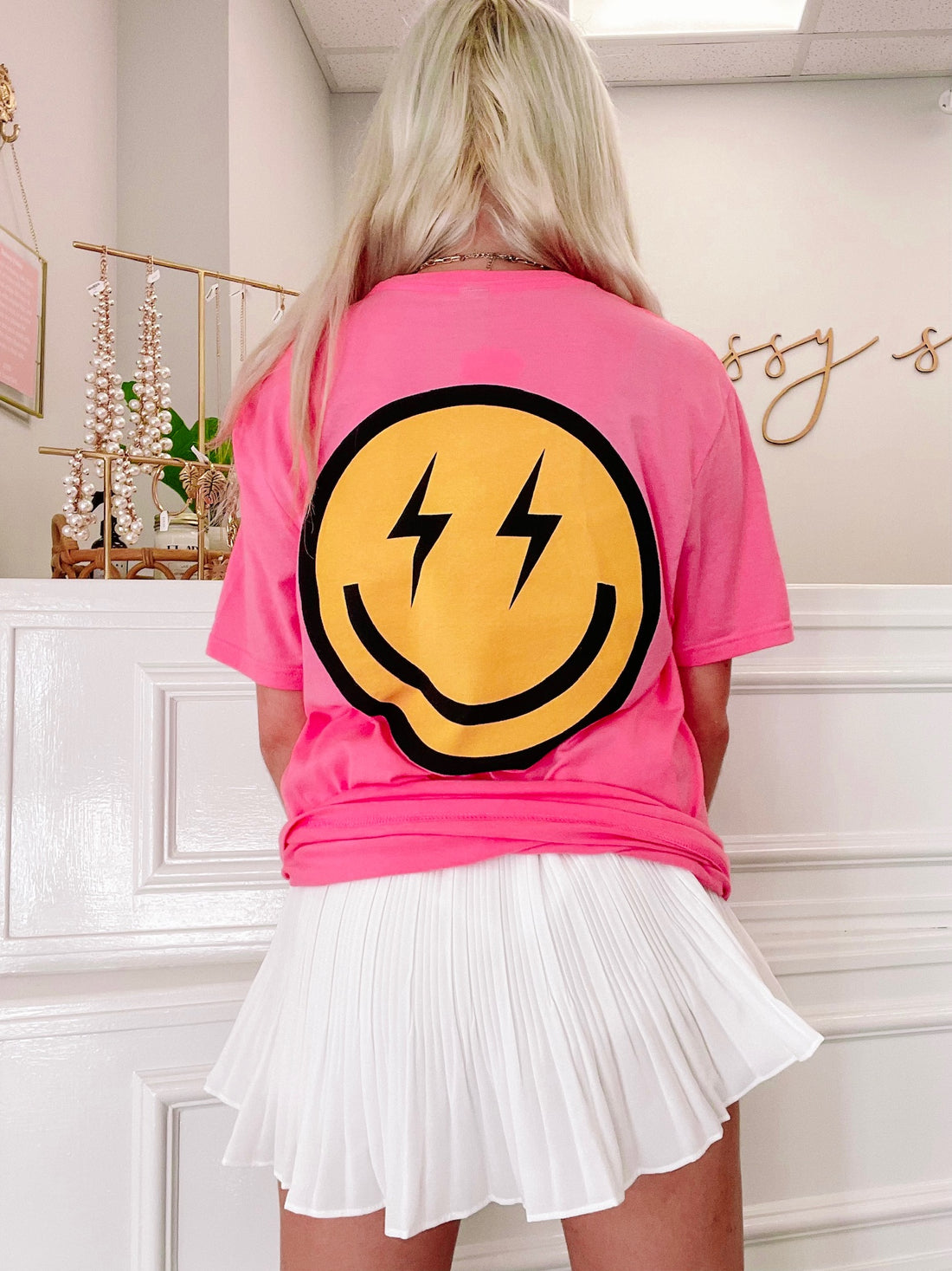 Pink Electric Smiles tee with bold yellow smiley face graphic on back.
