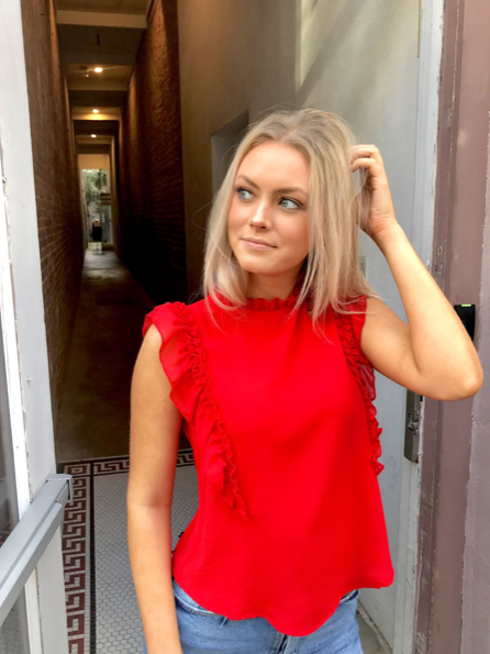 Red Ruby Ruffles sleeveless top with ruffle detailing.

