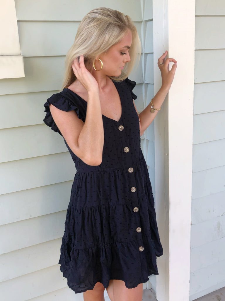 Black Abigail eyelet mini dress with tiered ruffle hem and button front.
