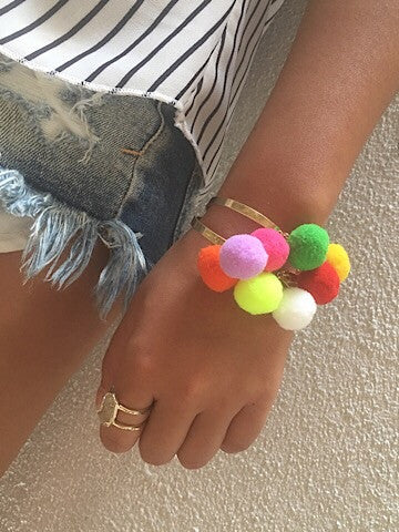 Pom City multicolor pom-pom bracelet; gold bangle.
