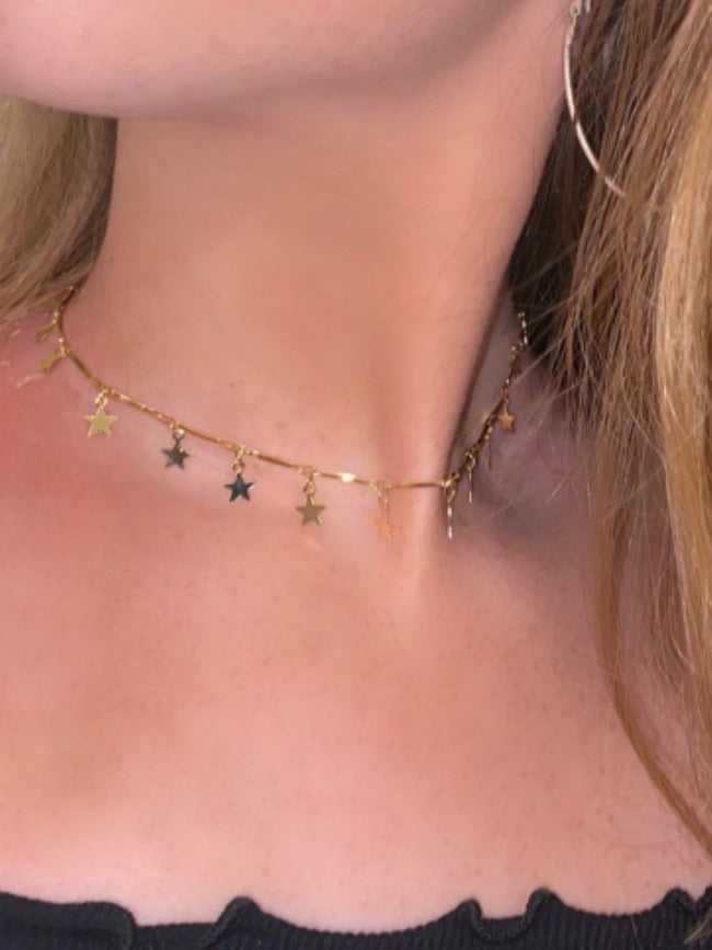 Gold Stargazer choker necklace with dangling star charms.
