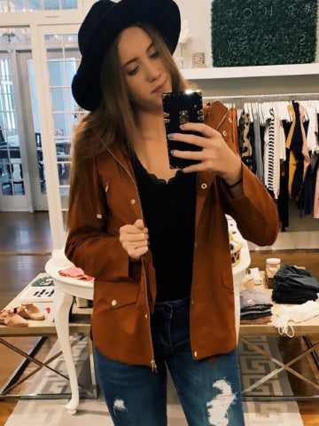 Brown corduroy jacket with gold buttons, modeled in a boutique setting.
